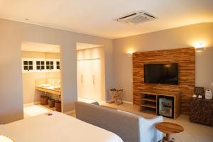 a living room with a fireplace and a television at Pousada Zé Maria in Fernando de Noronha