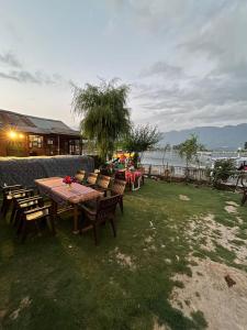 a group of tables and chairs on the grass near the water at Hotel Lake Side in Srinagar +7 photos