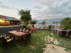 a patio with tables and chairs and a river at Hotel Lake Side in Srinagar