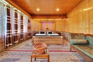 a bedroom with a bed and a couch and a chair at Hotel Lake Side in Srinagar