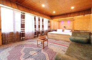 a bedroom with a bed and a couch in a room at Hotel Lake Side in Srinagar