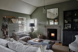 a living room with a couch and a fireplace at Banchory Farm in Fife