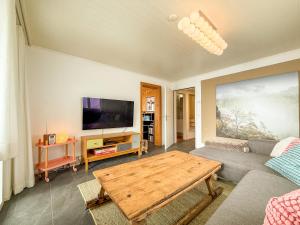 a living room with a couch and a table at Chalet apartment with Mountain View in Bettmeralp