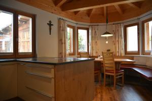 a kitchen and dining room with a table and chairs at Das DolomitenNest in Dölsach