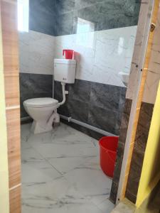 a bathroom with a toilet and a sink at Shivmandir Homestay in Siliguri +11 photos
