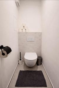 a bathroom with a white toilet and a black rug at Košice Kysucka Apartment in Košice