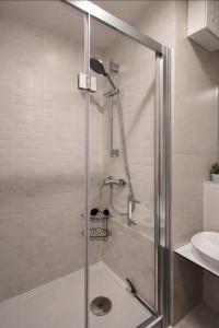 a shower with a glass door in a bathroom at Košice Kysucka Apartment in Košice