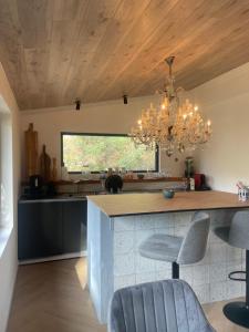 a kitchen with a large island with a chandelier at La Noirie in Saint-Étienne