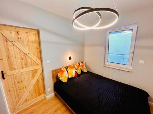 ein Schlafzimmer mit einem Bett, einem Fenster und einer Tür in der Unterkunft Bydgoszcz GOLD 7 z sypialnią in Bydgoszcz