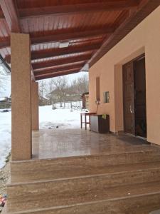 a porch of a house with a door and a table at Colț de Rai in Pirotehnia