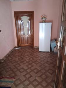 a room with a refrigerator and a wooden door at Colț de Rai in Pirotehnia