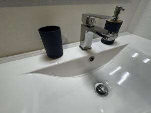 a sink with a faucet and a cup on it at Hiking & Ocean in Arco da Calheta