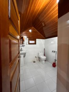 a bathroom with a toilet and a sink at Kehkashan in Shongran