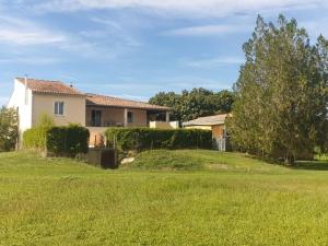 a house on a grassy hill with a yard at Au bout du chemin Chez Tina in Sarrians