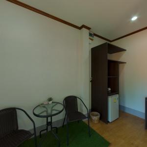 Zimmer mit einem Tisch, Stühlen und einem Kühlschrank in der Unterkunft Rim Khao Resort in Ko Lanta