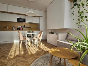 a kitchen and living room with a couch and a table at LAM Design Greenery AC - Balcony in Bratislava