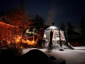 a snow covered camper in the snow at night at Hedetangen AuroraHut wintertime in Lungsundet