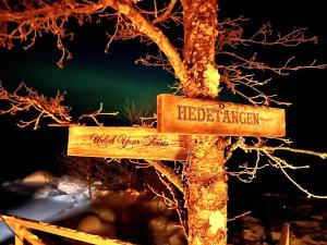 a wooden sign with the words liberalism and needed at Hedetangen AuroraHut wintertime in Lungsundet