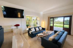 a living room with a couch and a table at Villa Nobleza, oasis con piscina y gimnasio a 2 min del centro in El Port de la Selva