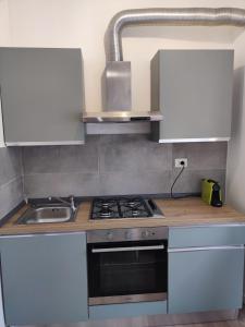 a kitchen with a stove and a sink at La Strada di Tiziano in Pieve di Cadore
