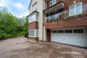 a brick house with two white garage doors at Personal En-suite in Shrewsbury