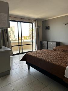 a hotel room with a bed and a large window at Hotel Capri in Iquique +23 photos