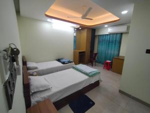 a room with two beds and a ceiling at MD HoTEL in Iswardi