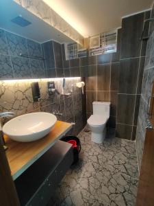 a bathroom with a sink and a toilet at MD HoTEL in Iswardi