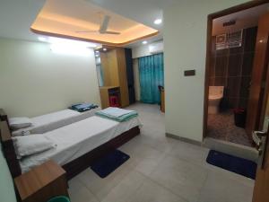 a room with two beds and a bathroom with a shower at MD HoTEL in Iswardi