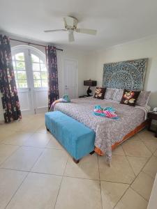 a bedroom with a bed with a blue ottoman at 108 Sapphire Beach Condos Barbados in Christ Church +17 photos