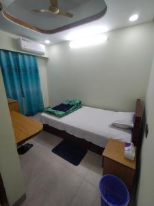 a small room with a bed and a blue curtain at MD HoTEL in Iswardi +3 photos