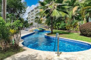 a swimming pool in a resort with a bridge at 108 Sapphire Beach Condos Barbados in Christ Church