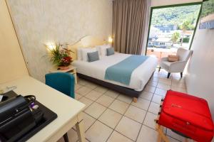 a hotel room with a bed and a desk and a room at Sure Hotel by Best Western Gemenos en Provence in Gémenos