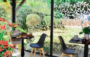 a patio with two tables and chairs in front of a window at Sure Hotel by Best Western Gemenos en Provence in Gémenos