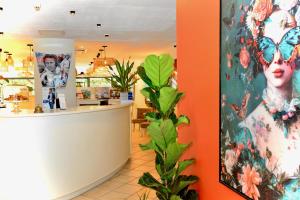 a shop with a counter and a painting of a woman at Sure Hotel by Best Western Gemenos en Provence in Gémenos