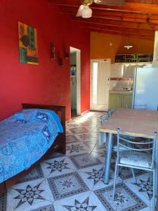 a bedroom with a bed and a table and a kitchen at Departamento El Delfín in Tanti +3 photos