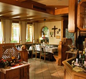 a kitchen with a table and chairs and a cross on the wall at Hotel Walkenstein in Oberwolfach