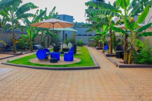 a playground with blue chairs and an umbrella at Moto-Moto Cottages in Mbarara +4 photos
