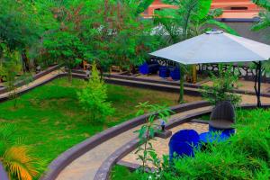 a patio with an umbrella and a table and chairs at Moto-Moto Cottages in Mbarara