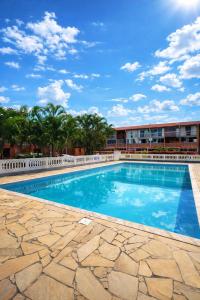a swimming pool in front of a building at Chalé Maresia Maranduba in Maranduba