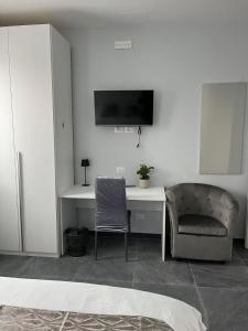 a room with a desk and a chair and a tv at James Home in Quarto dʼAltino