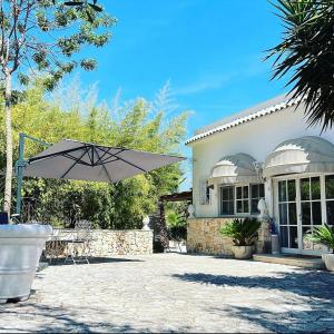 a white house with an umbrella in front of it at Il Saraceno B&B in Carovigno