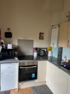 a kitchen with white cabinets and a stove top oven at A Wee Cottage In Dunfermline in Dunfermline +31 photos