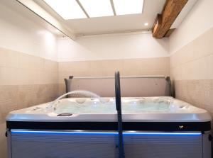 a hot tub in a bathroom with a ceiling at Les Bobos à la ferme in La Madelaine-sous-Montreuil +109 photos