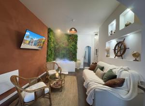 a living room with a white couch and chairs at La suite Carthagène des Indes - centre ville , spa & terrasse privée in Béthune