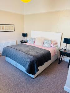a bedroom with a large bed with two night stands at A Wee Cottage In Dunfermline in Dunfermline