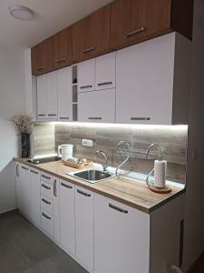 a kitchen with white cabinets and a sink at Divci Nova1- A8 in Divčibare