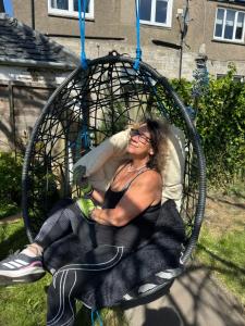 a woman sitting in a tire swing at A Wee Cottage In Dunfermline in Dunfermline
