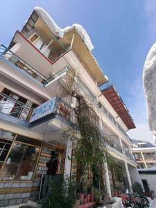 a man standing in front of a building at Joeys Hostel Manali in Manāli