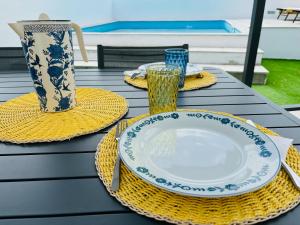 a table with plates and glasses and a vase at Cantinho do Alandroal in Alandroal
